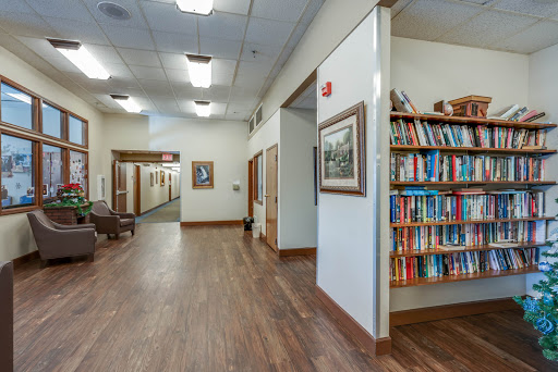 A well-lit hallway featuring a bookshelf and framed artwork.