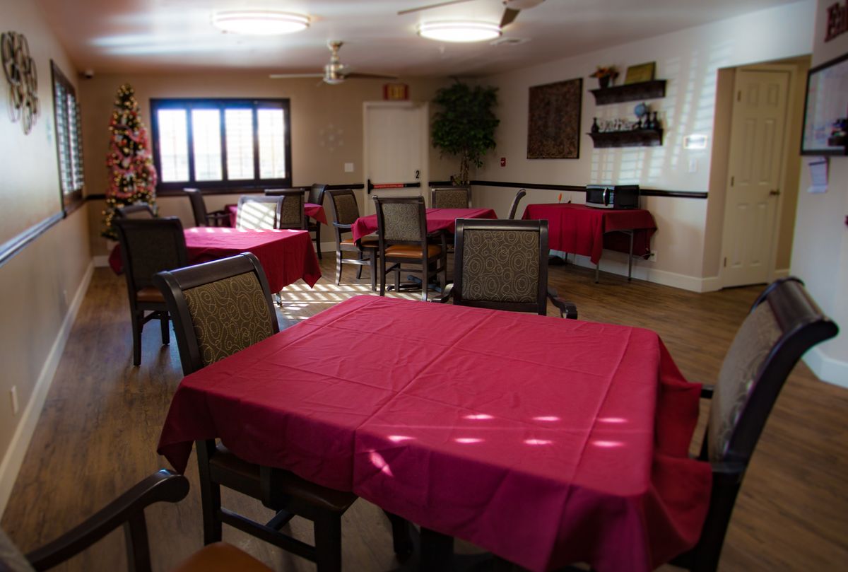 A cozy dining room with tables covered in red tablecloths and various seating arrangements.