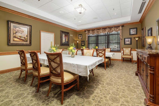 A spacious and elegantly decorated dining room featuring a large table, comfortable chairs, and tasteful artwork.