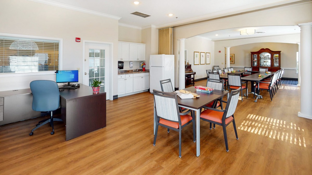 A modern dining and kitchenette area with wooden floors and comfortable seating.