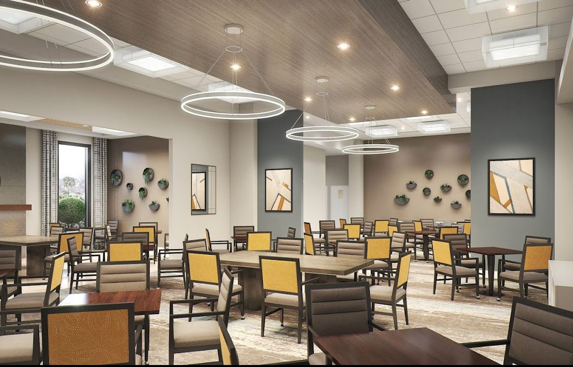 A modern dining area with stylish lighting and neatly arranged tables and chairs.