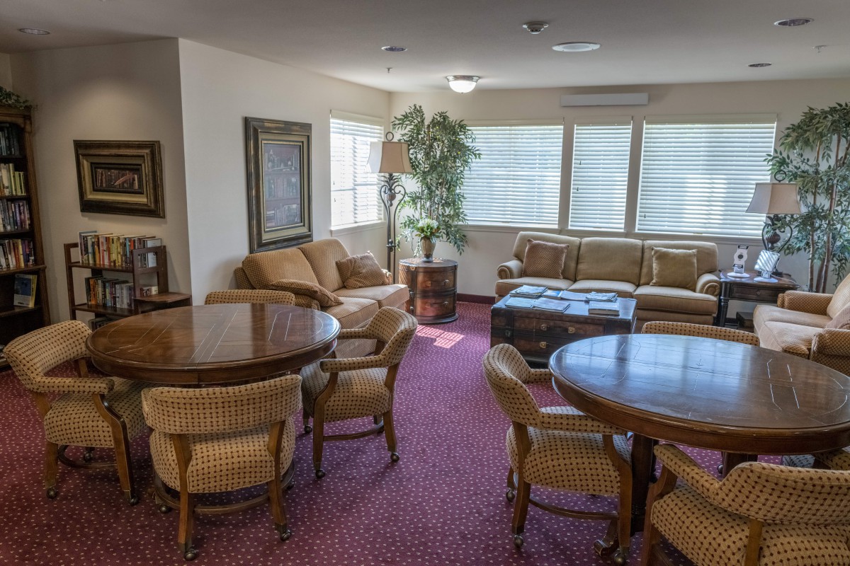 A cozy living room with sofas, chairs, tables, and a carpet.