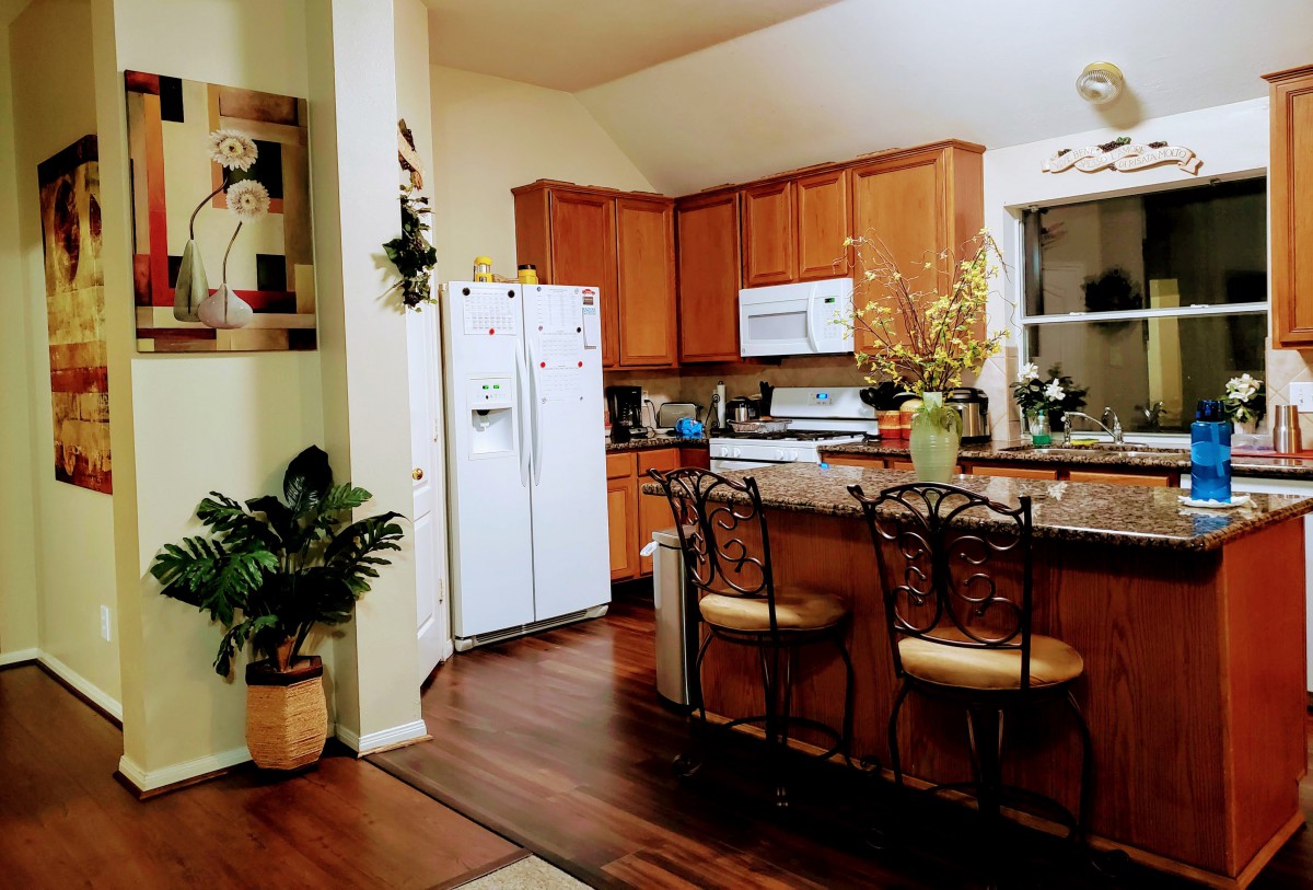 A cozy kitchen with wooden cabinets, white appliances, and inviting decor.