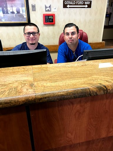 Two staff members smiling at the reception desk.