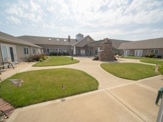 A well-maintained building with landscaped gardens and a clear sky.