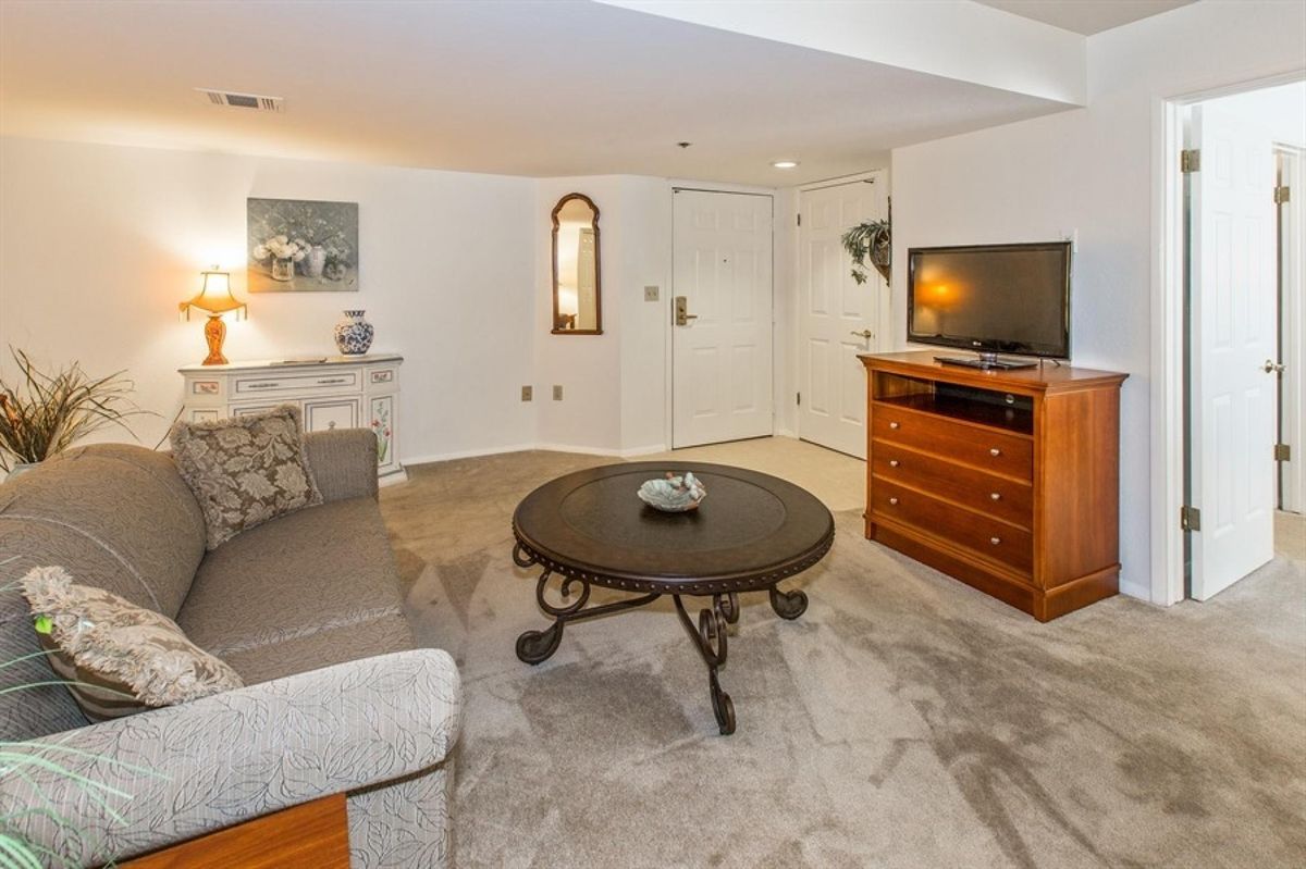 A cozy living room featuring a sofa, a decorative coffee table, and a television setup.