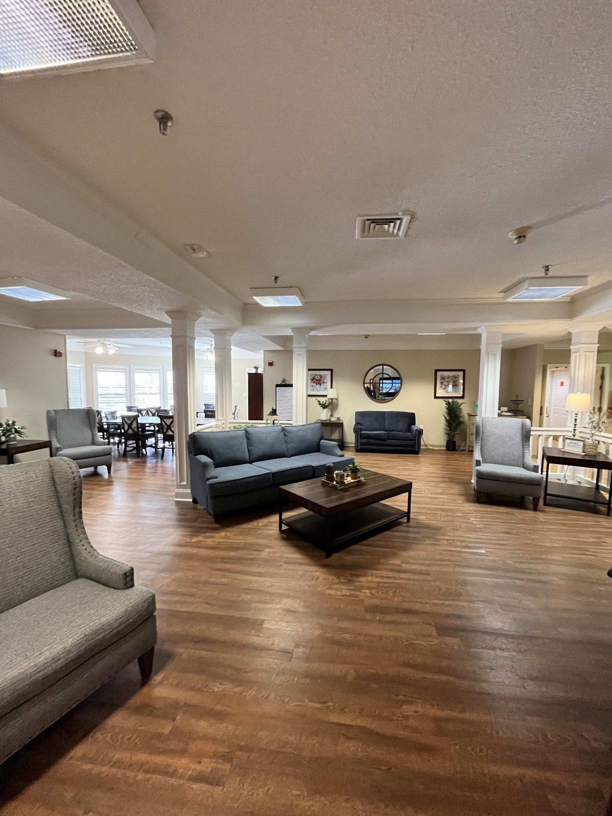 A spacious and elegantly decorated living room with modern furniture and wooden flooring.
