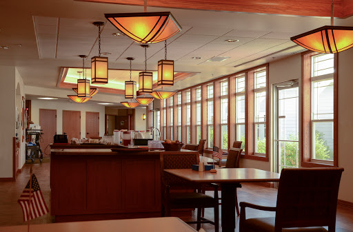 A warm and inviting restaurant interior featuring stylish lighting and large windows.