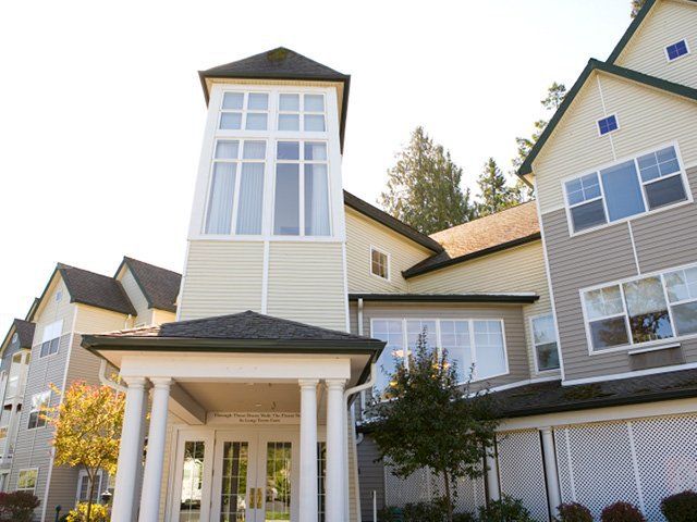 A modern residential building with large windows and a prominent entryway.