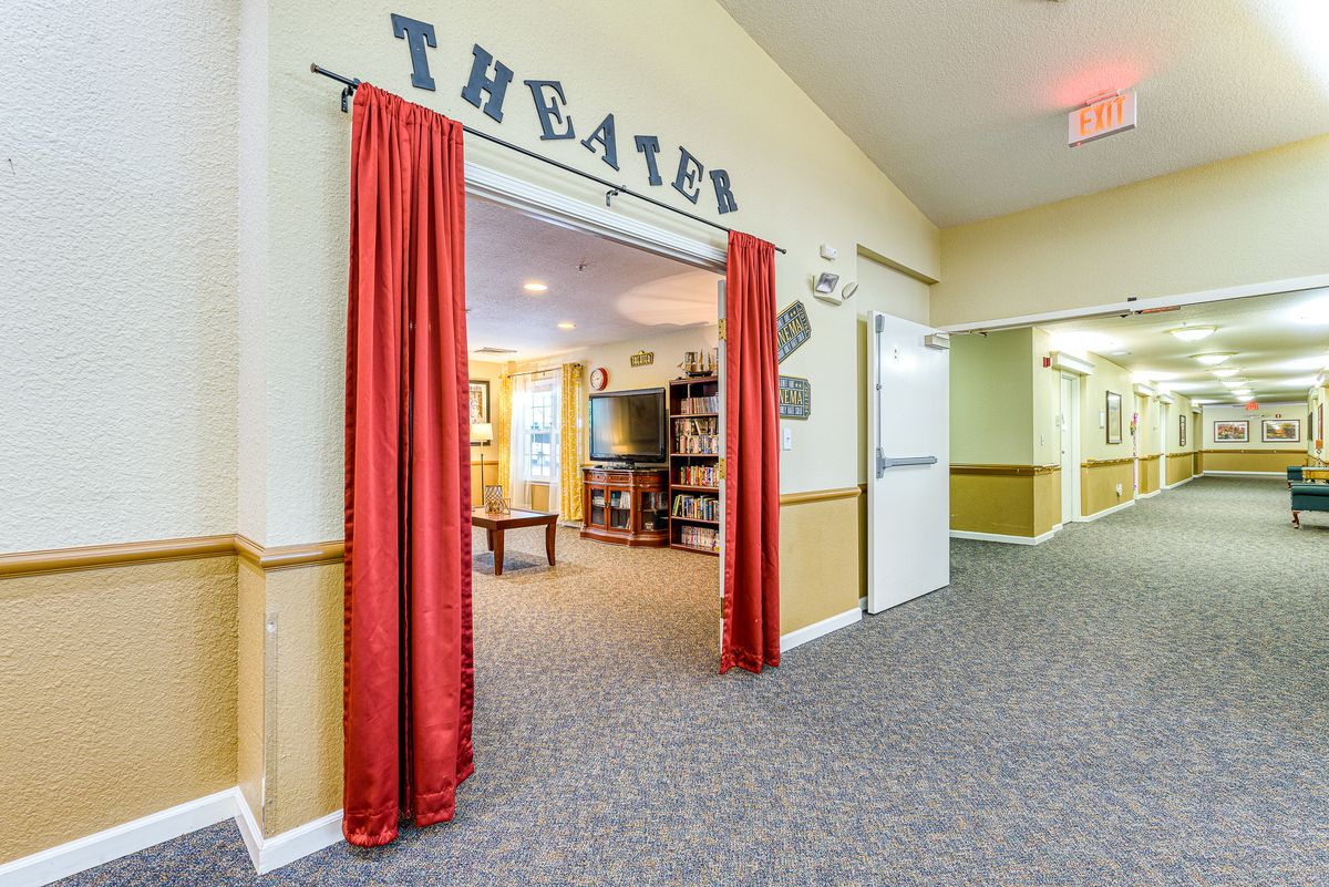 The entrance to a theater room with red curtains and a carpeted hallway.