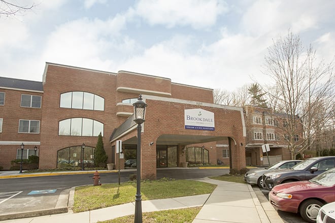 A modern healthcare facility with a brick exterior and designated parking area.