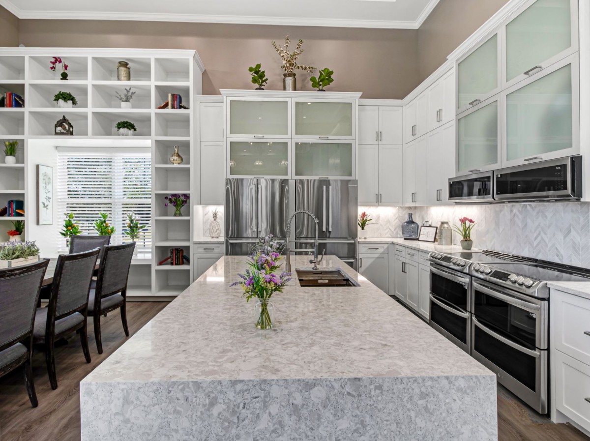 A modern kitchen with white cabinets and stainless steel appliances.