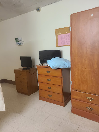 A simple bedroom setup featuring two dressers and two televisions.