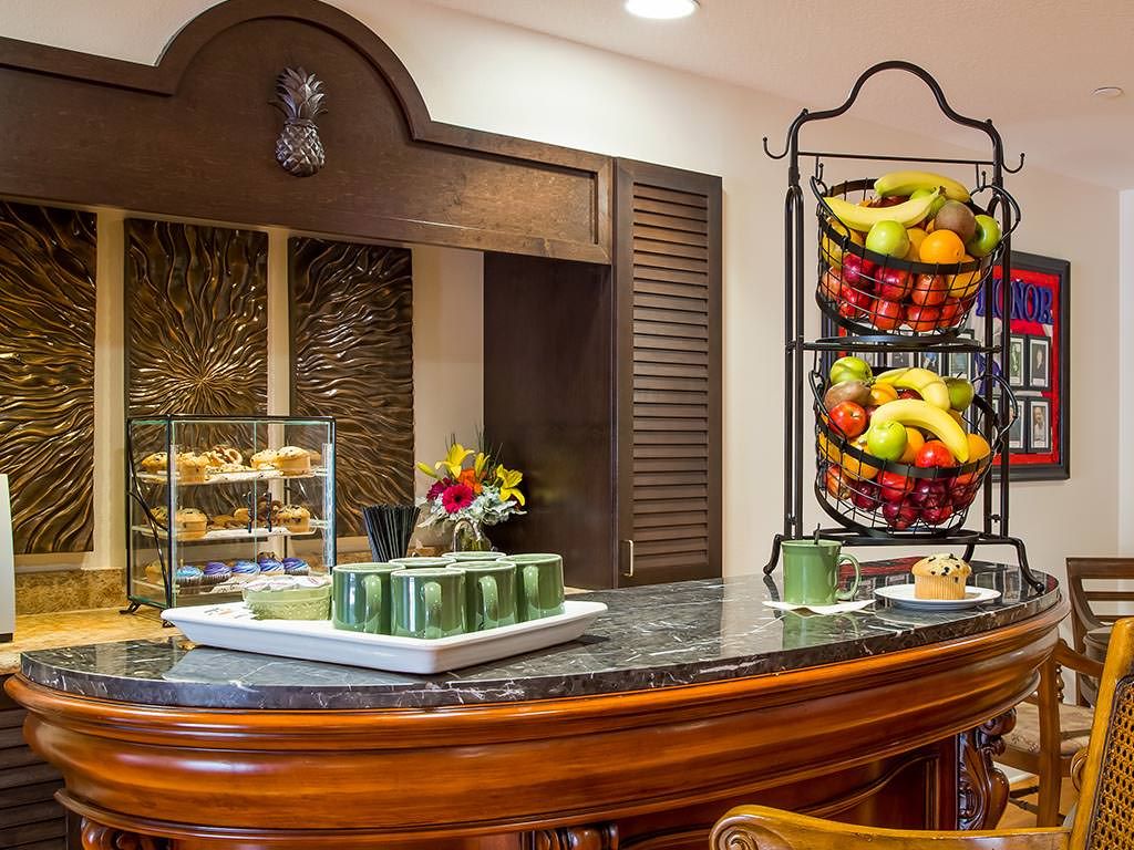 A breakfast buffet setup with a variety of fruits and pastries on display.