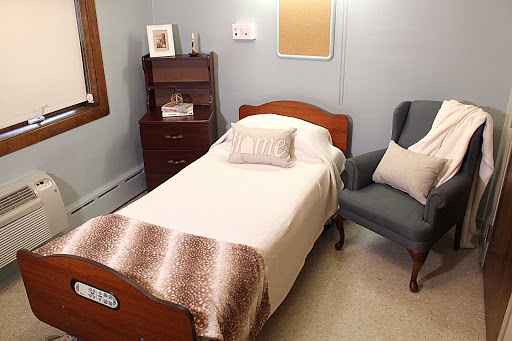 A cozy bedroom featuring a single bed, a comfortable armchair, and tasteful decor.