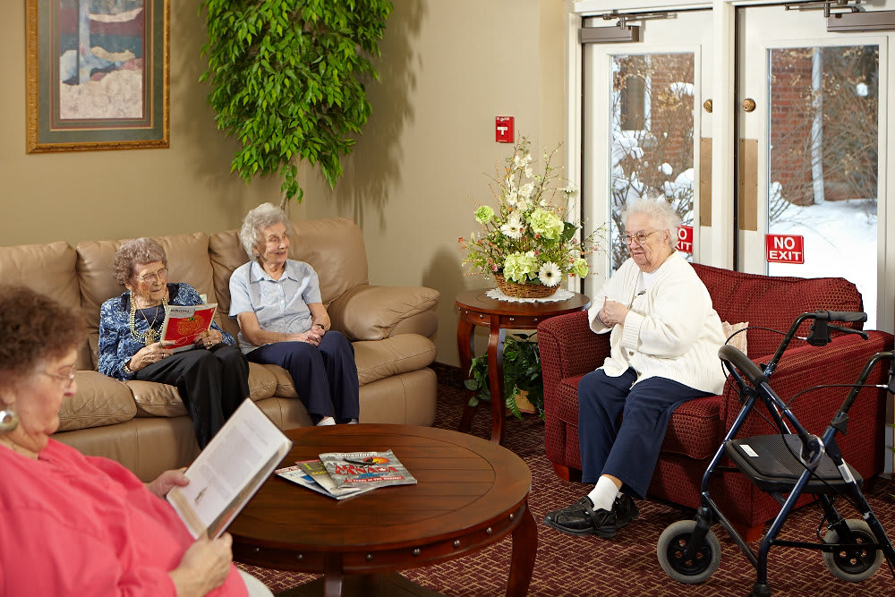 A group of seniors having a conversation in a cozy living room setting.