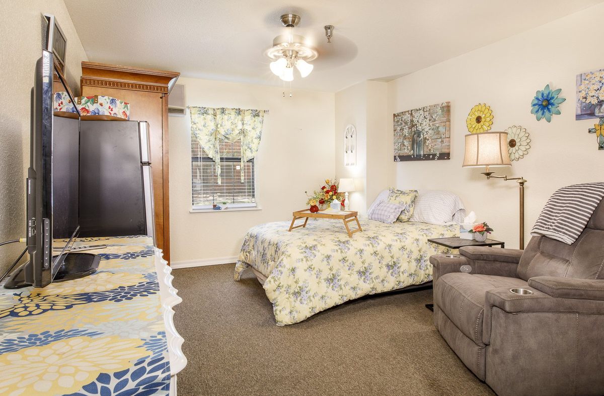 A cozy bedroom with floral patterns and comfortable furnishings.