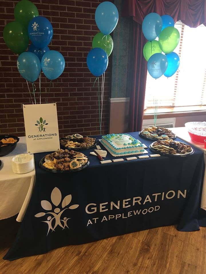 A decorated table at an event featuring balloons, snacks, and a cake.