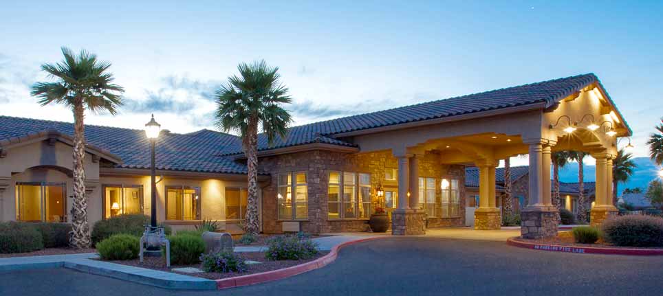 A beautifully lit building with palm trees at dusk.