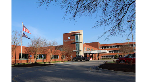 A modern healthcare facility set against a clear blue sky.