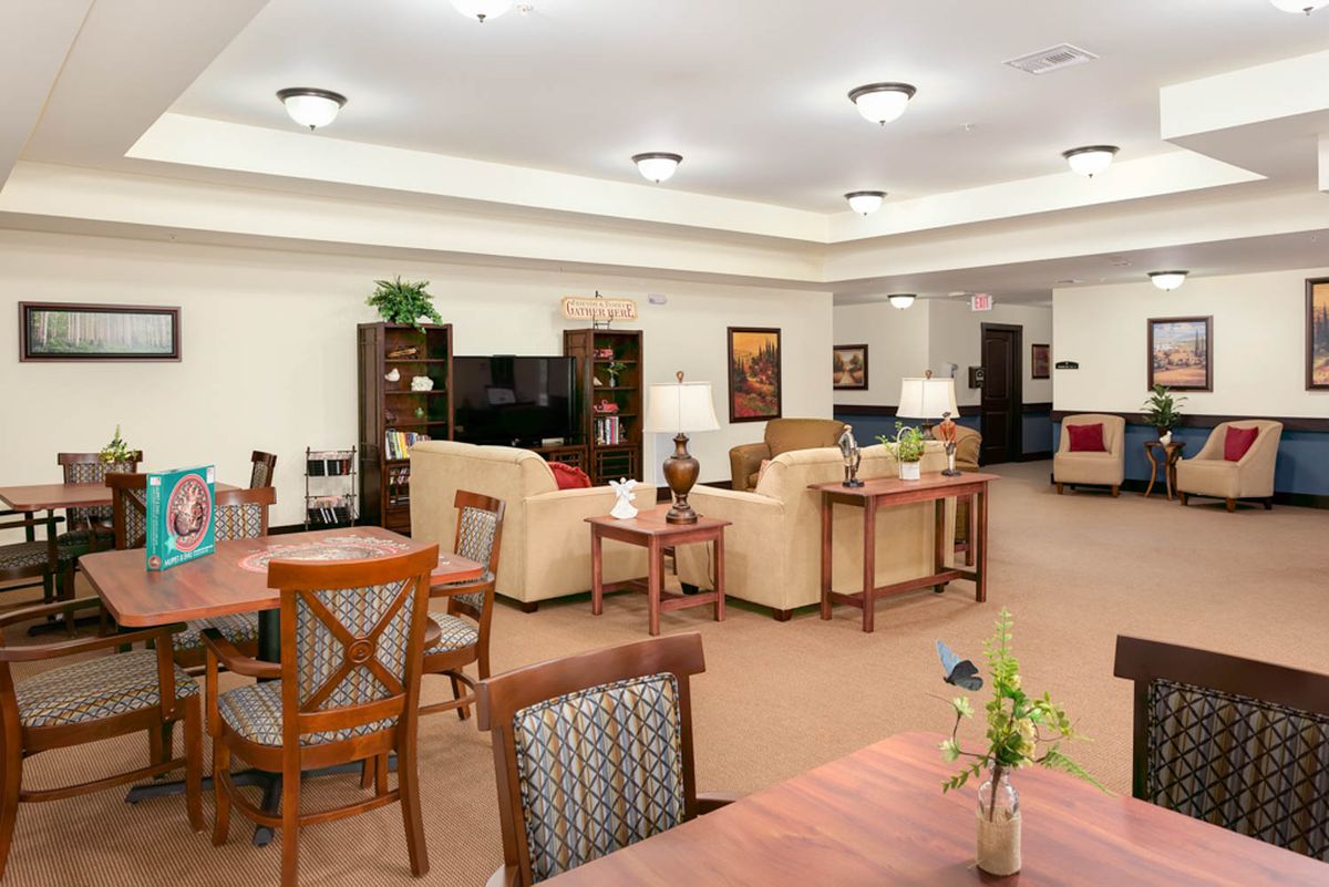 A cozy living area with comfortable sofas, tables, and warm lighting.