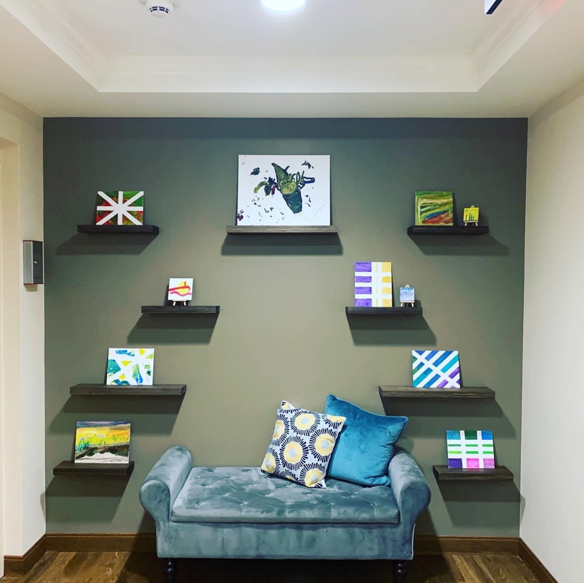 A cozy corner with a stylish sofa, decorative shelves, and vibrant artwork.