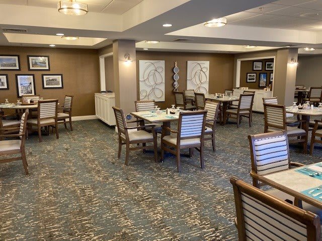 An elegantly decorated dining area with multiple tables and chairs arranged neatly.