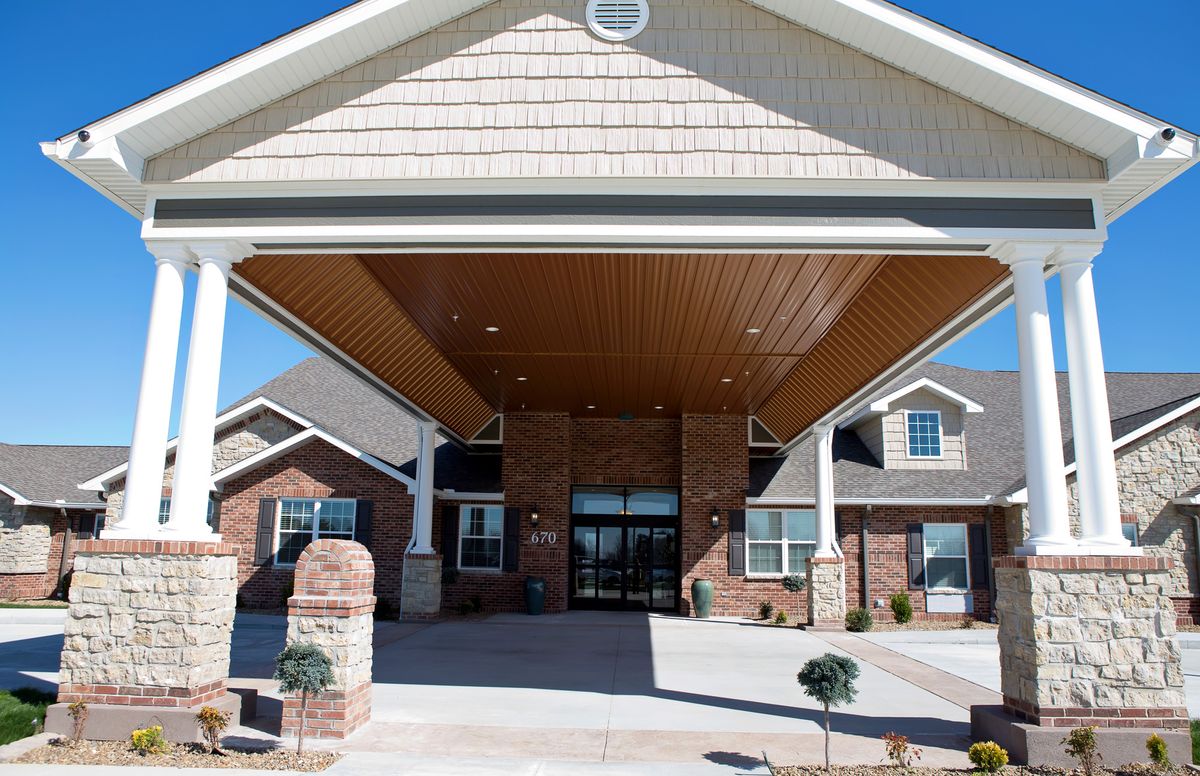 Front entrance of a modern brick building with white columns.