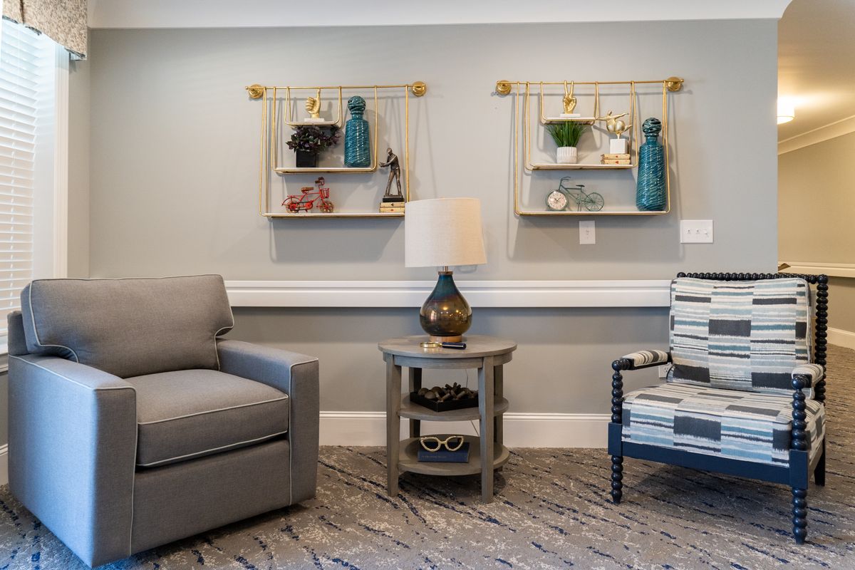 A cozy living room with modern furniture and decorative shelves.