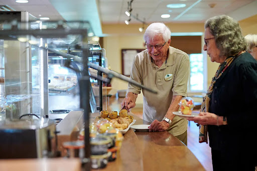 Seniors enjoying a meal at a buffet-style dining area.