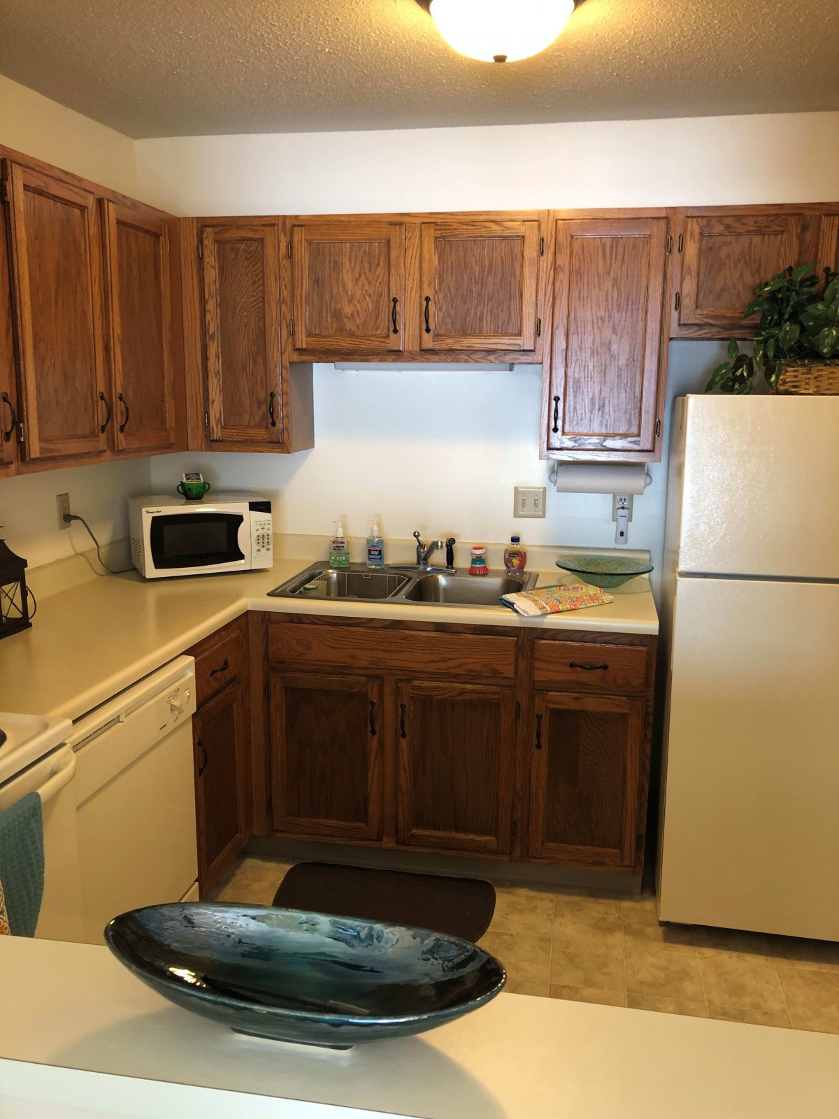 A cozy kitchen with wooden cabinets and essential appliances.