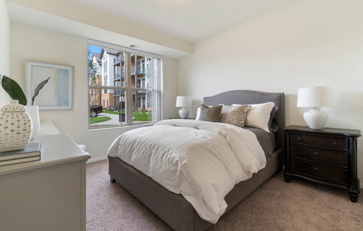 A modern bedroom with a large window letting in natural light.