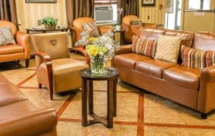 A cozy living room with comfortable seating and a vase of flowers on a side table.