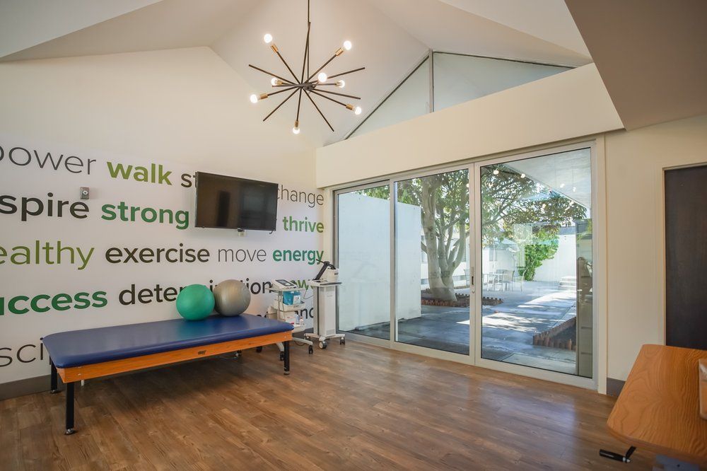 A modern exercise room featuring minimalist decor, large windows for natural light, and inspirational quotes on the wall.