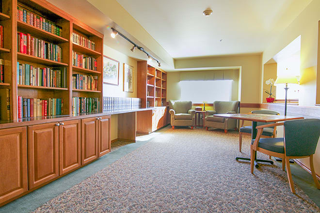 Cozy library reading area with bookshelves and comfortable seating.