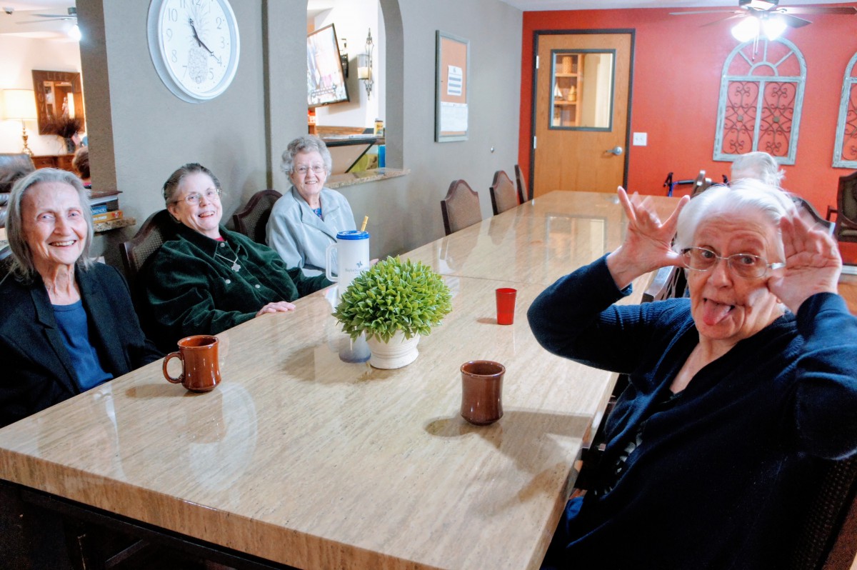 A group of people sitting around a table, engaging in conversation.