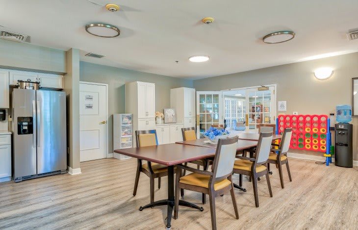 A modern dining or conference area with a large table and several chairs in a well-lit room.
