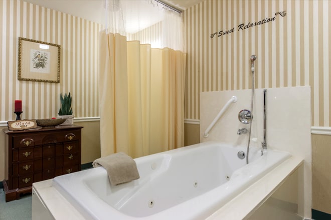 A modern bathroom with a large bathtub and surrounding curtains.