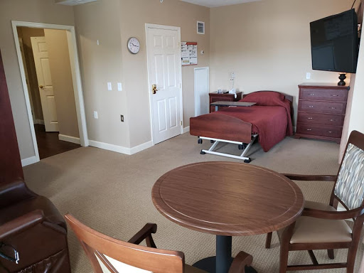 A cozy room featuring a bed, table, and chairs.