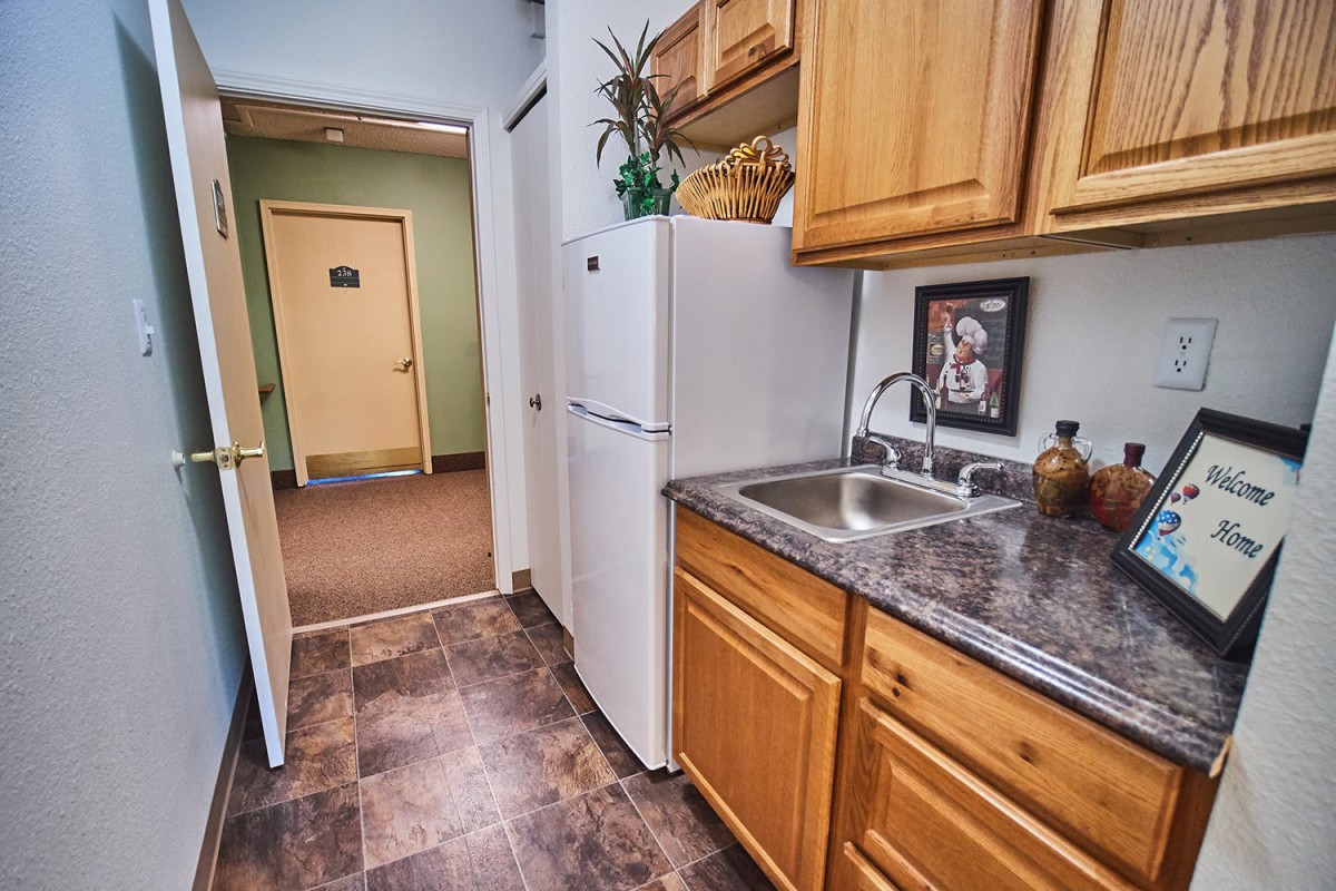 A cozy kitchen with wooden cabinets and a modern sink.