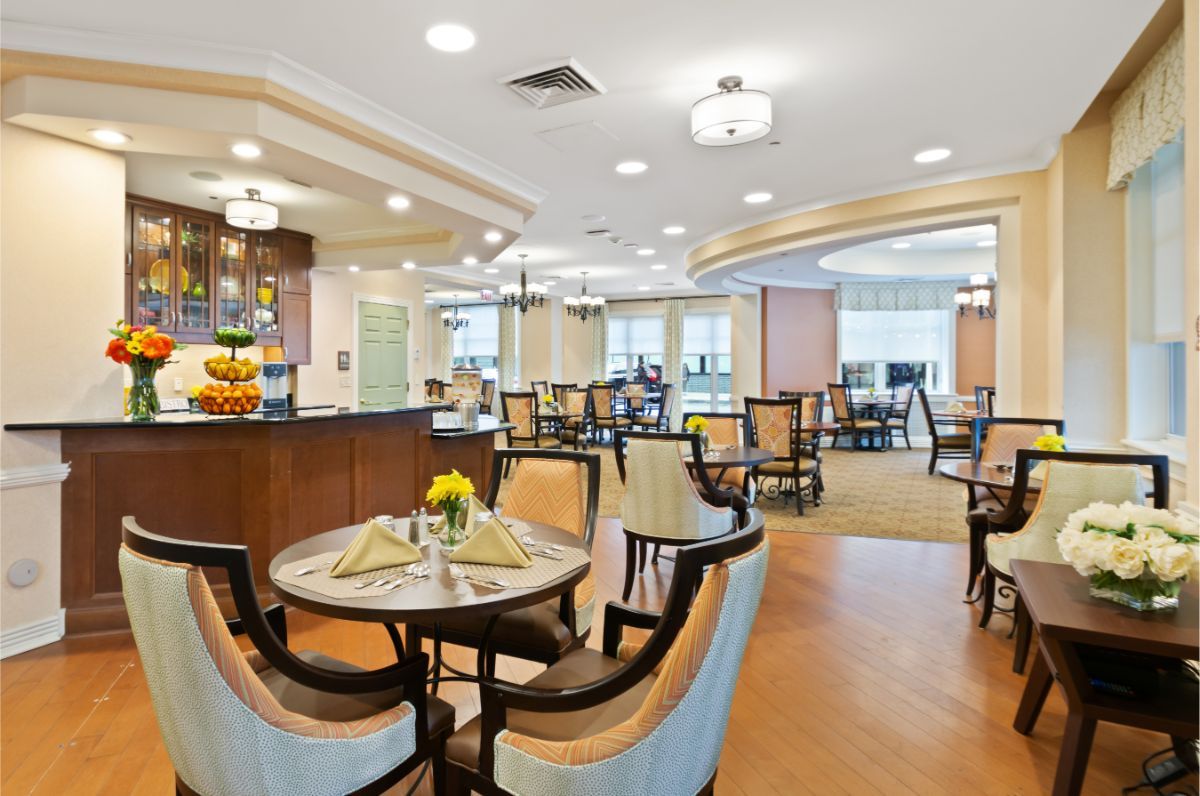 A well-lit dining area with elegantly arranged tables and chairs.