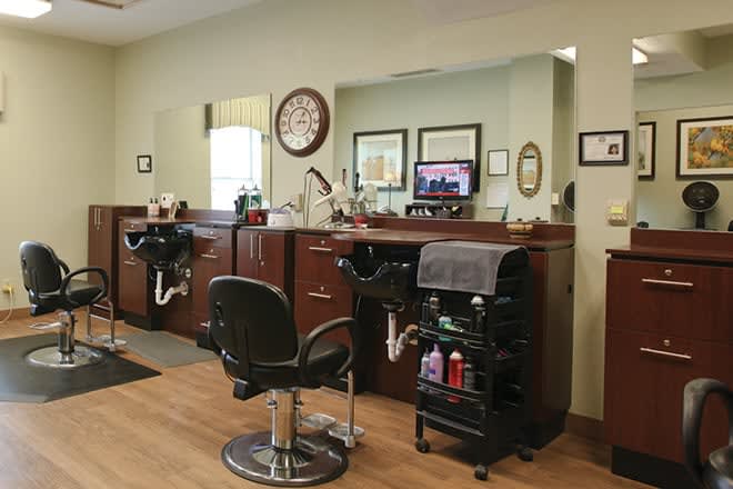 An interior view of a barbershop with chairs and mirrors.