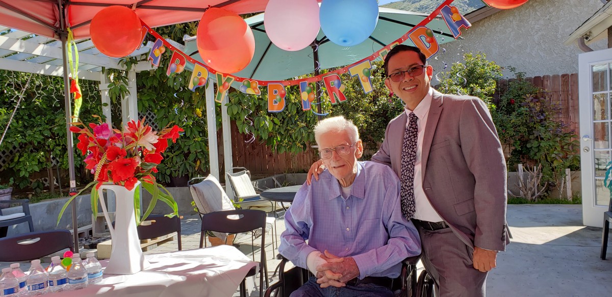 A joyful outdoor birthday celebration with colorful balloons and smiling participants.