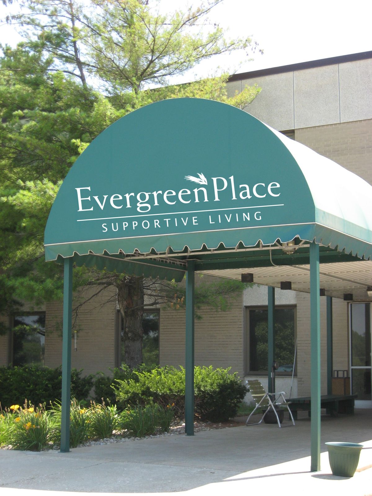 Entrance to Evergreen Place Supportive Living with a green awning.