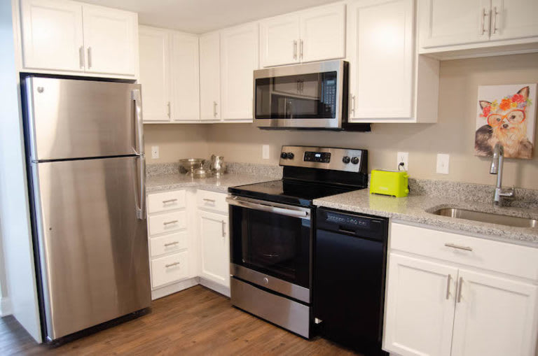 A modern kitchen with stainless steel appliances and white cabinets.