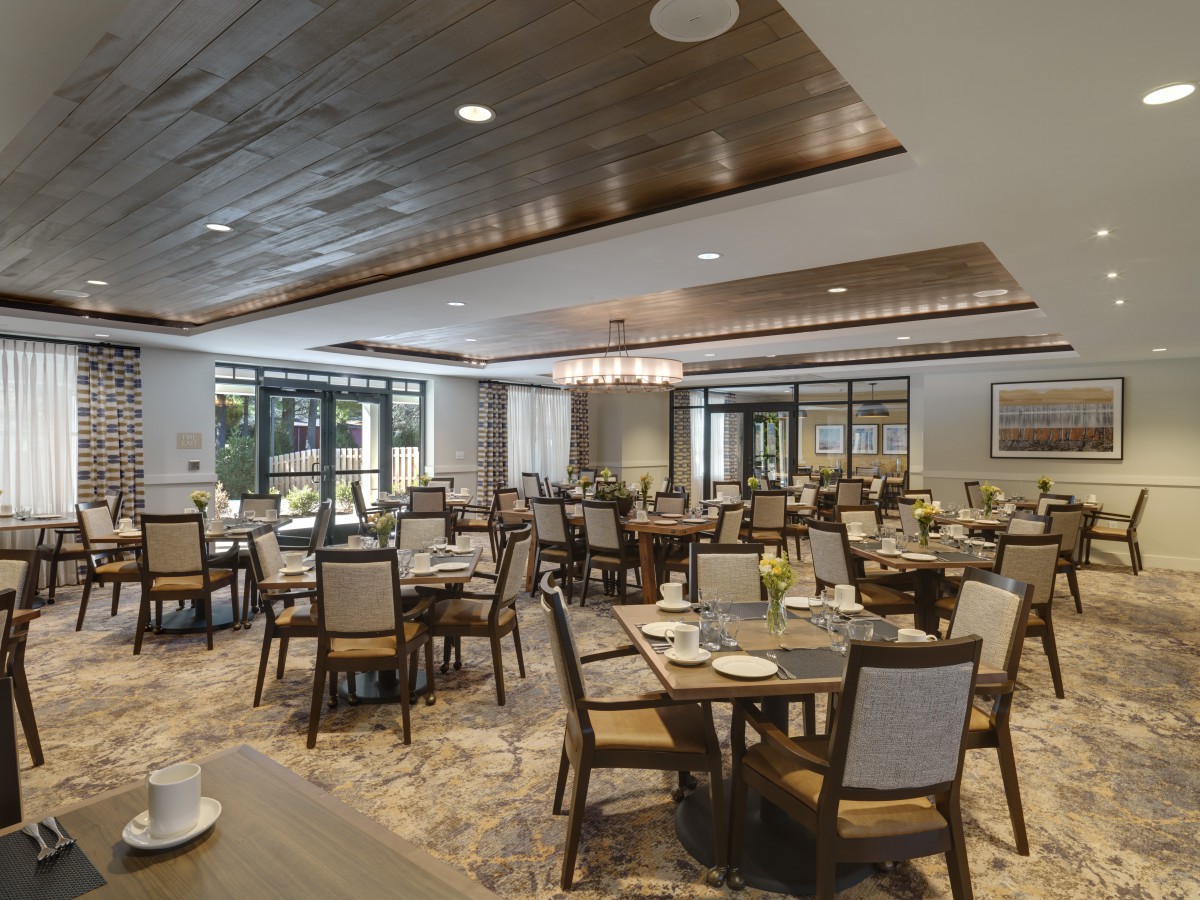 A spacious and elegantly designed dining area with neatly arranged tables and chairs.