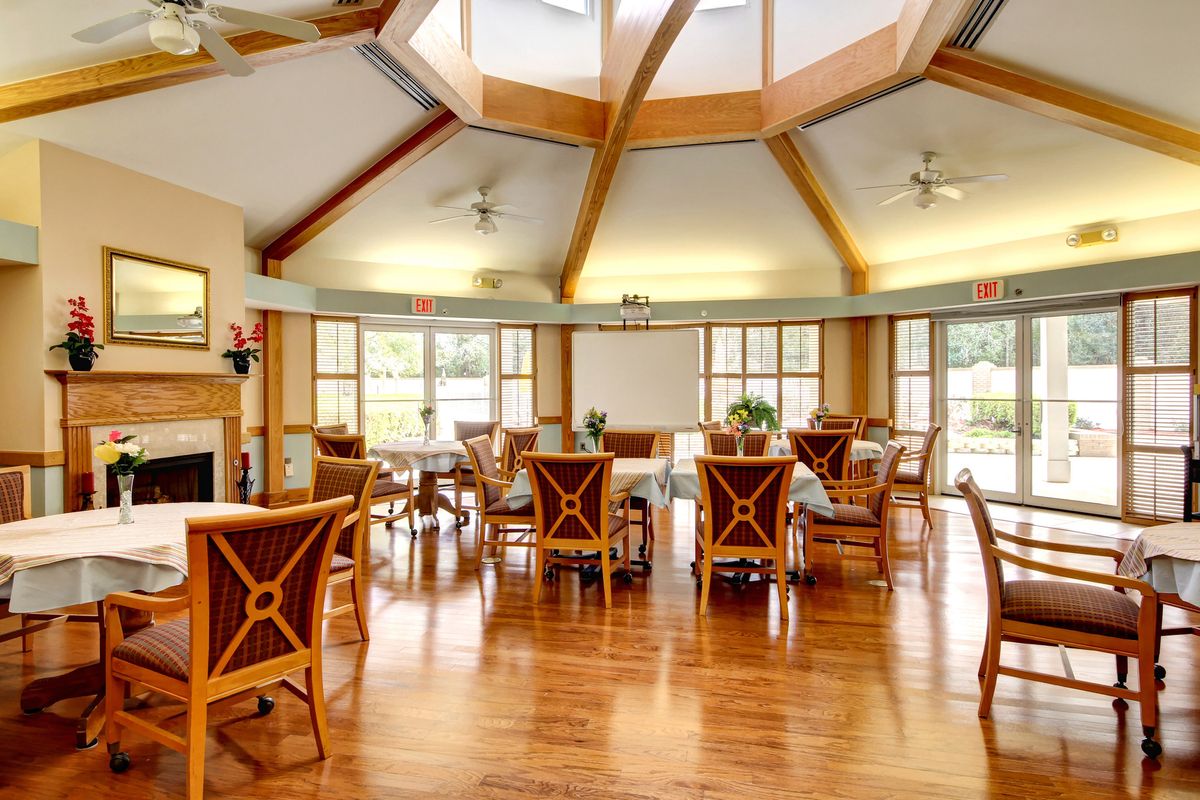 A spacious dining area with wooden furniture and large windows allowing natural light to fill the room.