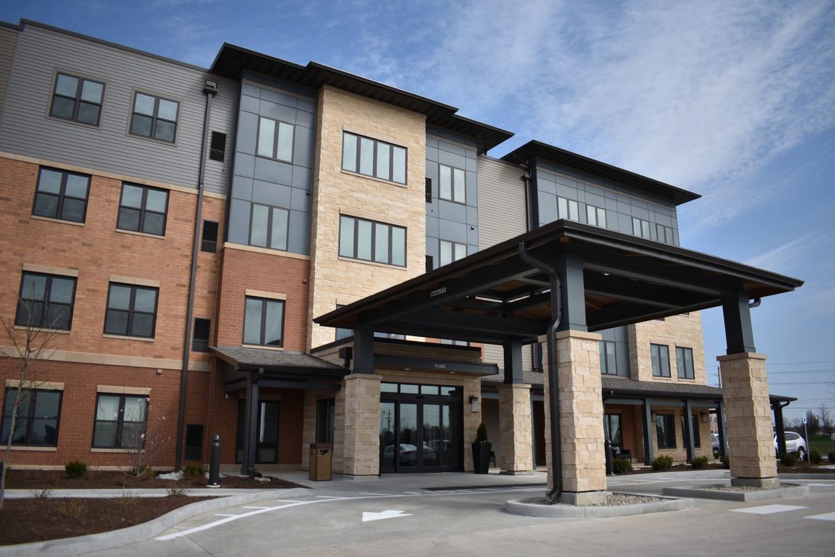 A modern building with mixed materials and a covered entrance.