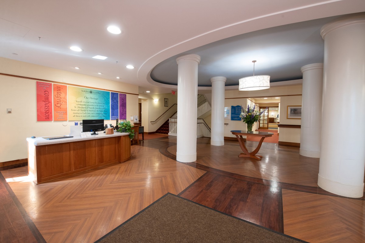 A modern lobby featuring a reception desk, colorful artwork, and elegant lighting.