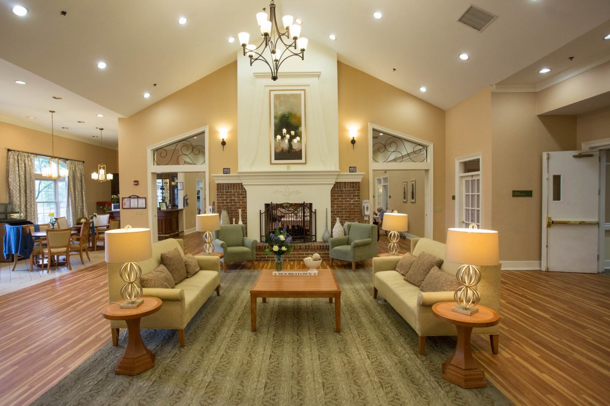 A cozy living room with elegant furniture and a central fireplace.